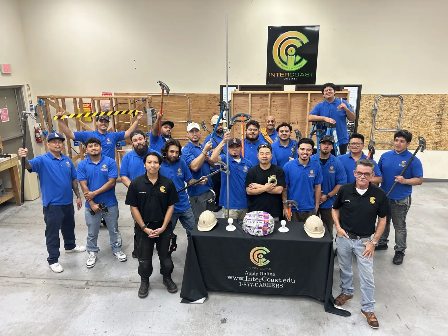 Electrical students at InterCoast's West Covina campus holding conduit benders and tools in the training lab, with two faculty members in front